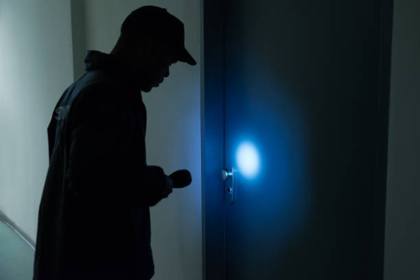 Male Security Guard With Flashlight Standing In Front Of Door
